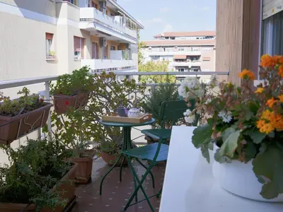 a balcony with a table and chairs and potted plants at La Casa dei Lettori in Rome