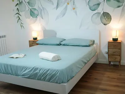 a bedroom with a bed with blue sheets and two lamps at La Casa dei Lettori in Rome