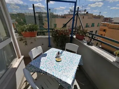 a table and chairs on a balcony with a view of a city at Il Melograno - Just like at home! in Rome