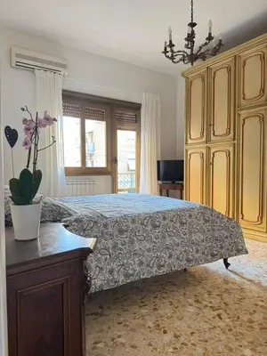 a bedroom with a large bed with a dresser and a potted plant at Ai Levii in Rome