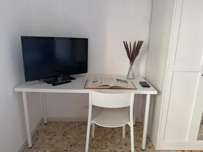 a white desk with a television and a book at Ai Levii in Rome