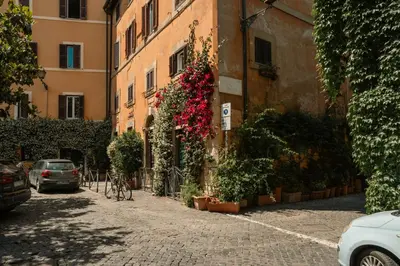 an alley in an italian city with flowering plants at Casa Verde - Luxury apartment in Trastevere in Rome