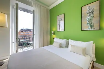 a bedroom with a white bed and a green wall at Casa Lilla in Rome