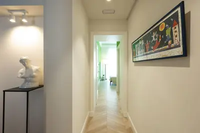 a hallway with a painting and a statue on a table at Casa Lilla in Rome