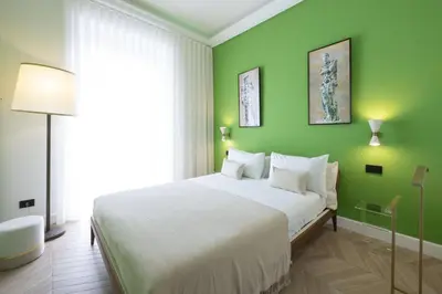 a bedroom with a large bed with green walls at Casa Lilla in Rome