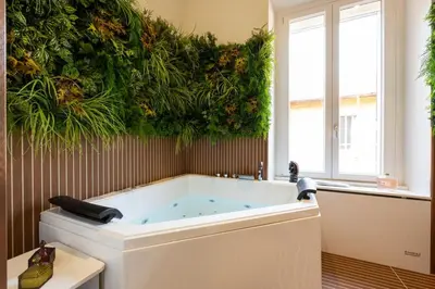 a bathroom with a tub with plants on the wall at Casa Lilla in Rome