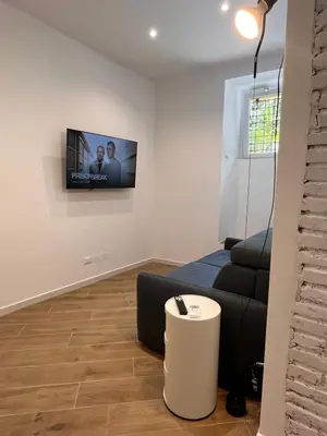a living room with a couch and a tv on the wall at Casa Vacanze Villa Barberina in Rome