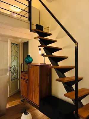 a wooden spiral staircase in a room with a vase at CasaNa' in Rome