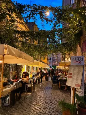 an outdoor market with tables and umbrellas on a street at CasaNa' in Rome