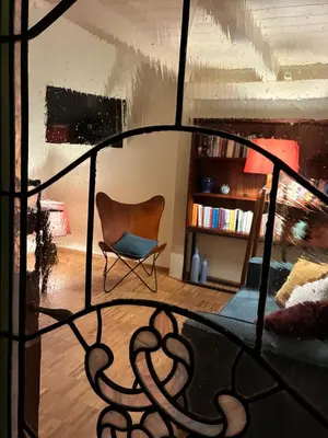 a living room with a chair and a book shelf at CasaNa' in Rome