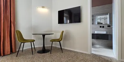 a room with two chairs and a table and a tv at Elegante Stanza Privata in Centro a Roma Colosseo - FLC Room in Rome in Rome