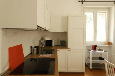 a small kitchen with white cabinets and a sink at P-House in Rome
