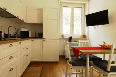 a kitchen with white cabinets and a table with a red table cloth at P-House in Rome
