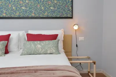 a bedroom with a bed with red and green pillows at Ostiense station penthouse in Rome