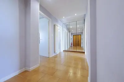 an empty hallway with white walls and a tile floor at Ostiense station penthouse in Rome