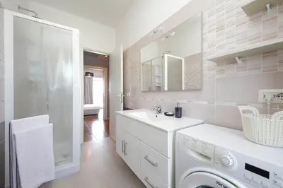 a bathroom with a sink and a washing machine at Ostiense station penthouse in Rome