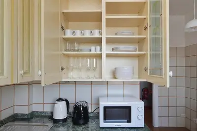 a kitchen counter with a microwave and some dishes at Ostiense station penthouse in Rome