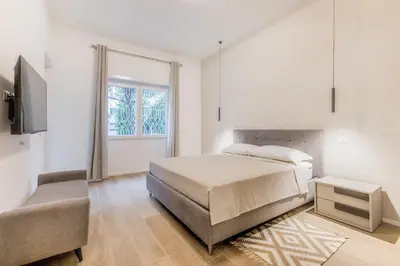 a white bedroom with a bed and a chair at Domus urbe San Paolo in Rome