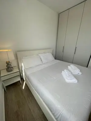 a white bed in a room with a night stand at YCH-Attico con splendida vista su Villa Ada in Rome