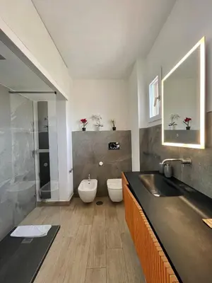 a bathroom with a sink and a toilet and a mirror at YCH-Attico con splendida vista su Villa Ada in Rome