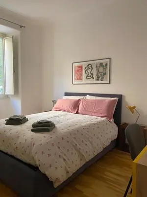 a bedroom with a bed with pink pillows on it at Civico 18 in Rome