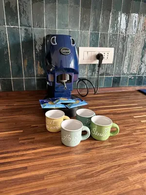 four coffee cups sitting on a table with a coffee maker at Leone's rooms - House for 6 people in Rome