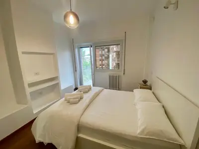 a bedroom with a large white bed with a window at Leone's rooms - House for 6 people in Rome