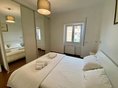 a large white bed in a room with a mirror at Leone's rooms - House for 6 people in Rome