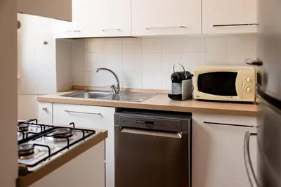 a small kitchen with a microwave and a stove at Casa Medea in Rome