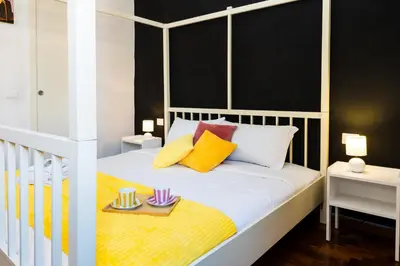a bedroom with a white bed with yellow and purple pillows at Casa Medea in Rome