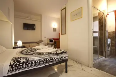 a bedroom with a bed and a tv on the wall at Rouge studio - 10 min from Vatican in Rome
