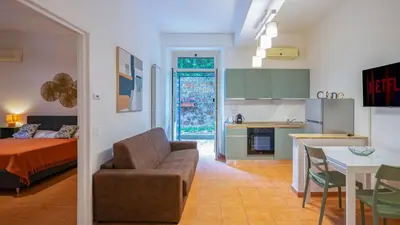 a living room with a couch and a bed and a kitchen at EasyTopStay - San Pietro Apartment with Courtyard in Rome