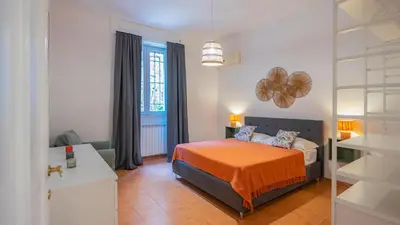 a bedroom with a bed with an orange blanket at EasyTopStay - San Pietro Apartment with Courtyard in Rome