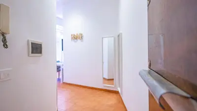 a hallway with a couch and a mirror on a wall at EasyTopStay - San Pietro Apartment with Courtyard in Rome