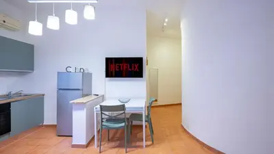 a kitchen with a table and chairs and a refrigerator at EasyTopStay - San Pietro Apartment with Courtyard in Rome