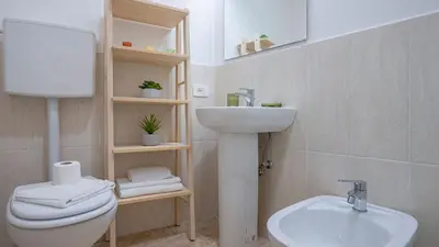 a bathroom with a white toilet and a sink at EasyTopStay - San Pietro Apartment with Courtyard in Rome