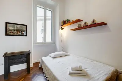 a small bedroom with a bed and a window at Elegant 3-Bedroom Apartment in Piazza Mazzini in Rome