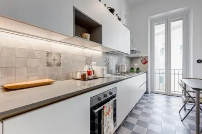 a kitchen with white cabinets and a counter top at Elegant 3-Bedroom Apartment in Piazza Mazzini in Rome