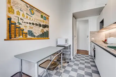 a kitchen with a table and a checkered floor at Elegant 3-Bedroom Apartment in Piazza Mazzini in Rome