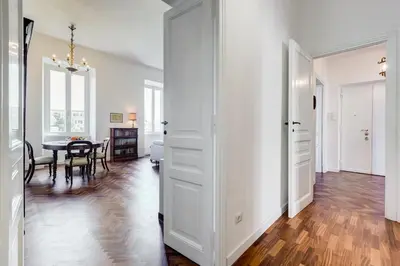 a white hallway with a dining room and a table at Elegant 3-Bedroom Apartment in Piazza Mazzini in Rome
