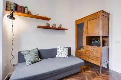 a living room with a couch and a wooden cabinet at Elegant 3-Bedroom Apartment in Piazza Mazzini in Rome