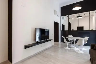a living room with a tv and a table and chairs at Maison Ottaviano -Vatican- in Rome