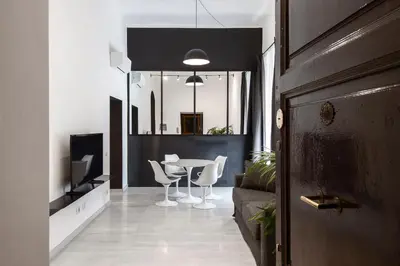 a living room with a table and white chairs at Maison Ottaviano -Vatican- in Rome