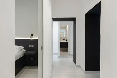 a bedroom with black and white walls and a hallway at Maison Ottaviano -Vatican- in Rome