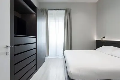 a bedroom with a bed and a tv and a window at Maison Ottaviano -Vatican- in Rome