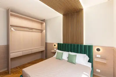 a bedroom with a bed with a green headboard at Iron Monti Coliseum in Rome