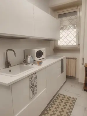 a kitchen with white cabinets and a sink and a window at Daniela's Home vicino a Metro A e Vaticano in Rome