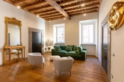a living room with a green couch and two white chairs at Fontana di Trevi Roma Luxury in Rome