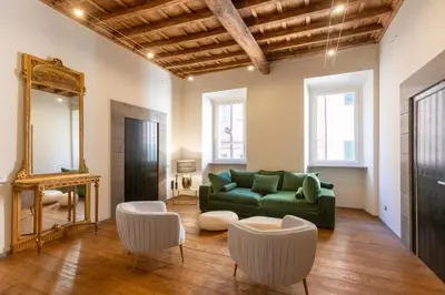a living room with a green couch and a mirror at Fontana di Trevi Roma Luxury in Rome