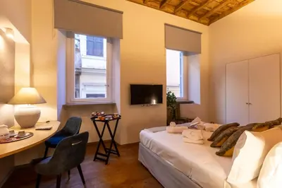 a bedroom with a bed and a desk and a tv at Fontana di Trevi Roma Luxury in Rome